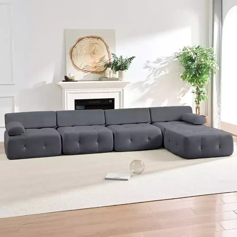 Divano sezionale in velluto a forma di L Mjkone, divano componibile a 4 posti con pouf, divani trasformabili con bordo borchiato