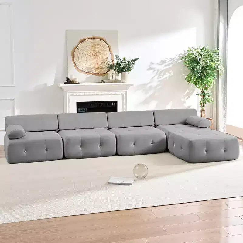 Divano sezionale in velluto a forma di L Mjkone, divano componibile a 4 posti con pouf, divani trasformabili con bordo borchiato